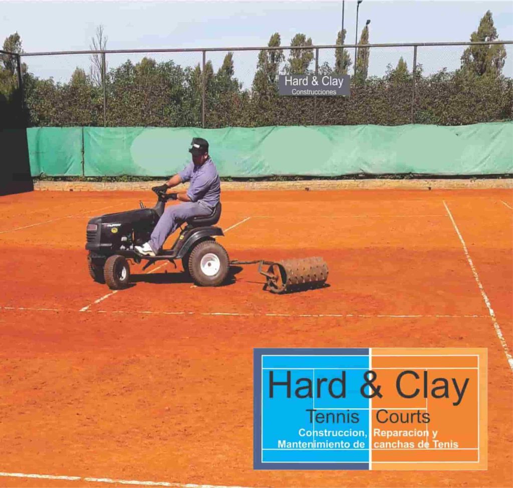 Trabajador preparando la cancha de polvo de ladrillo.